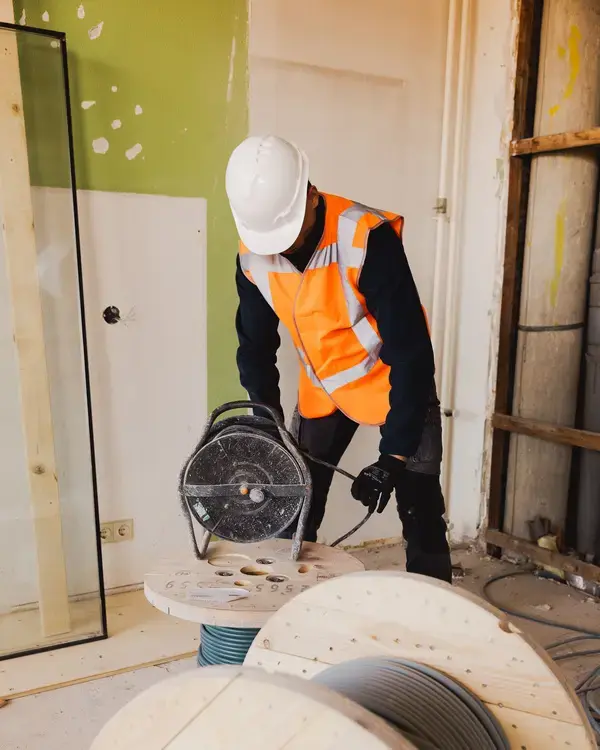 Medewerker met helm bij een kabelhaspel in een gebouw in aanbouw